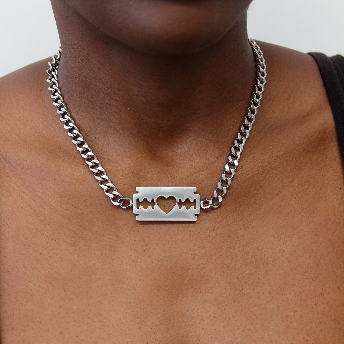 A commemorative necklace celebrating the twenty fifth anniversary of Razorblade Romance. A thick stainless steel chain with a razor blade pendant at the middle. 